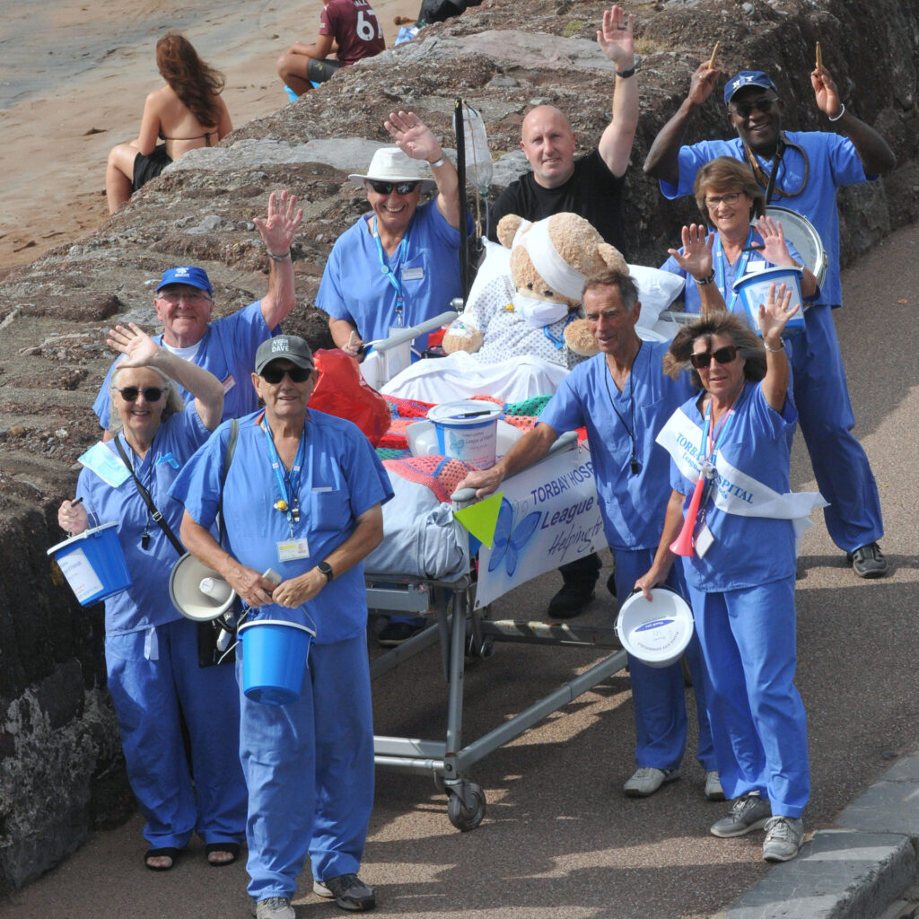 Volunteers from the Torbay Hospital League of Friends pushing a decorated hospital bed along the sea front on the August Bank Holiday Sunday to support patient care..