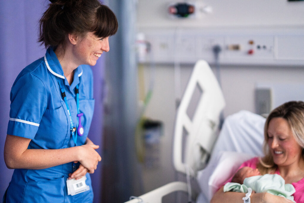 Midwife attending new mother and baby in a hospital setting