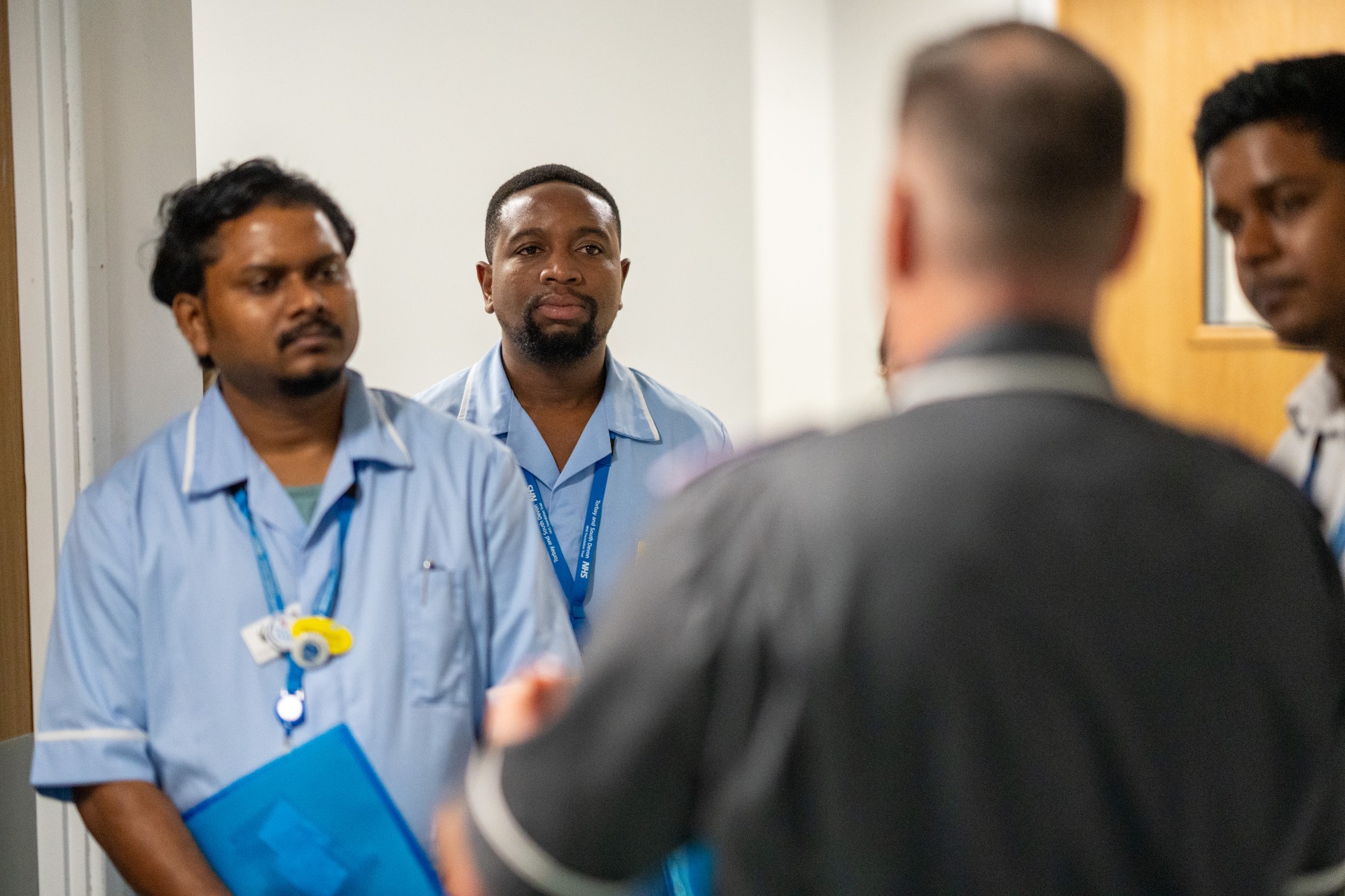 Four members of a medical team having a discussion, in a hospital setting