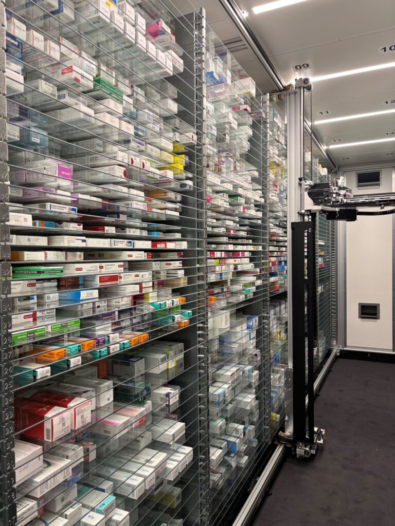 Inside the pharmacy dispensing room with medications held in a shelving system