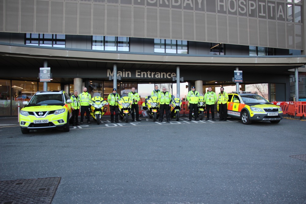 Some of the South West Blood Bikes volunteers standing with their vehicles outside Torbay Hospital's main entrance