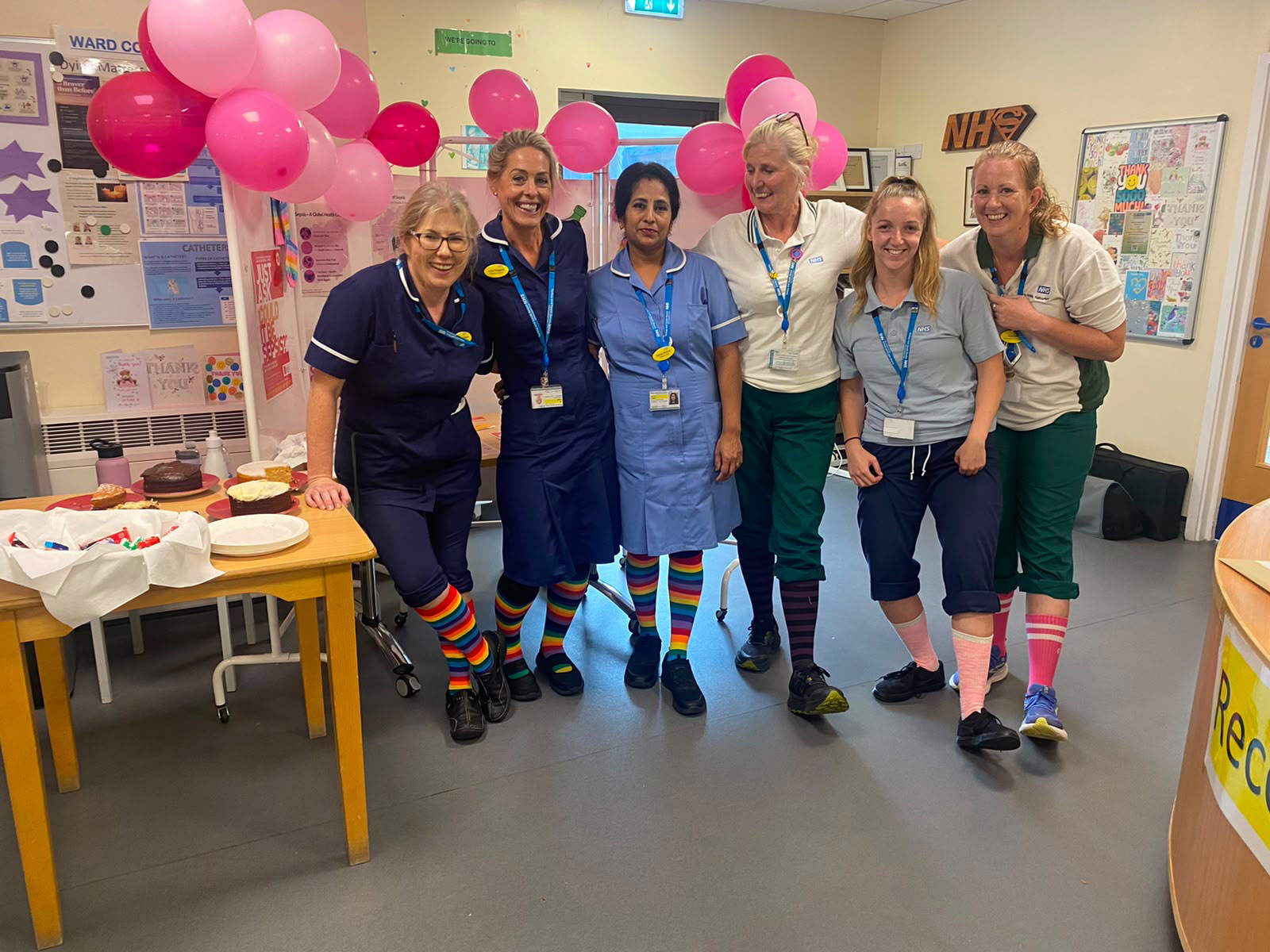 Colleagues marking Sepsis Awareness Day, wearing colourful socks.