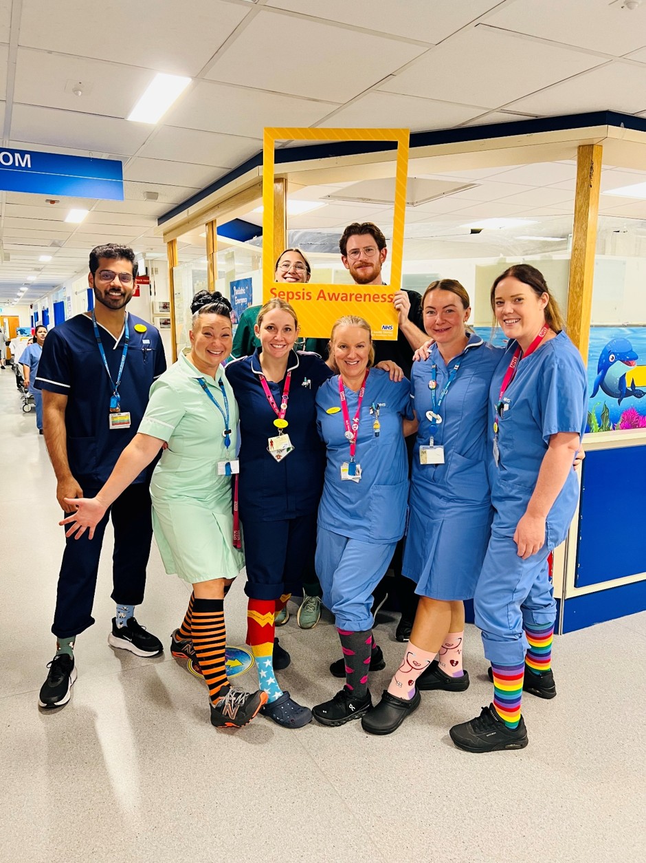 Colleagues marking Sepsis Awareness Day, wearing colourful socks.