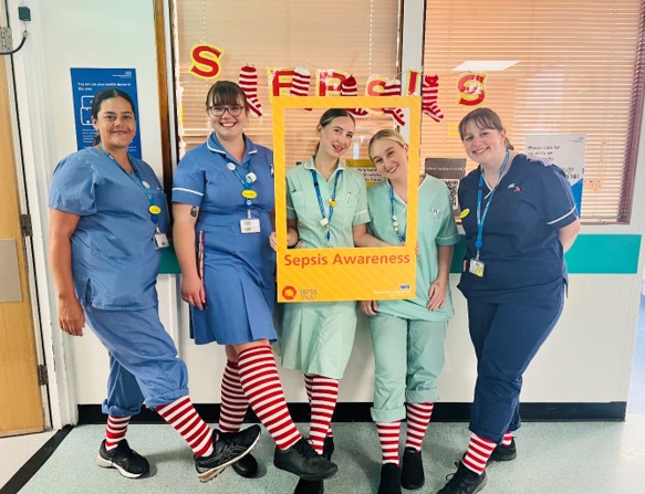 Colleagues marking Sepsis Awareness Day, wearing colourful socks.