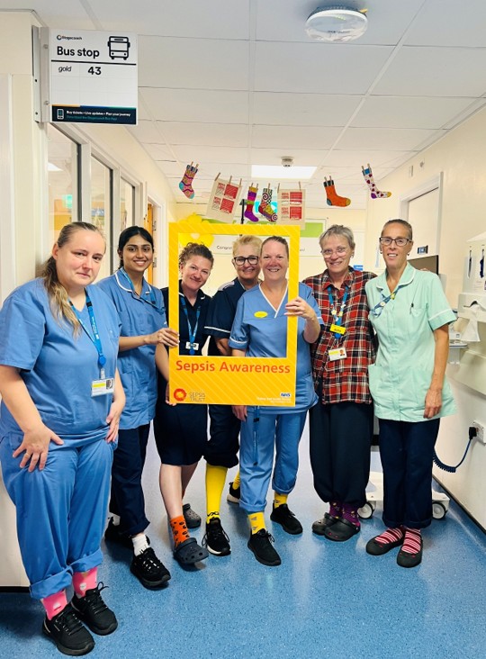 Colleagues marking Sepsis Awareness Day, wearing colourful socks.