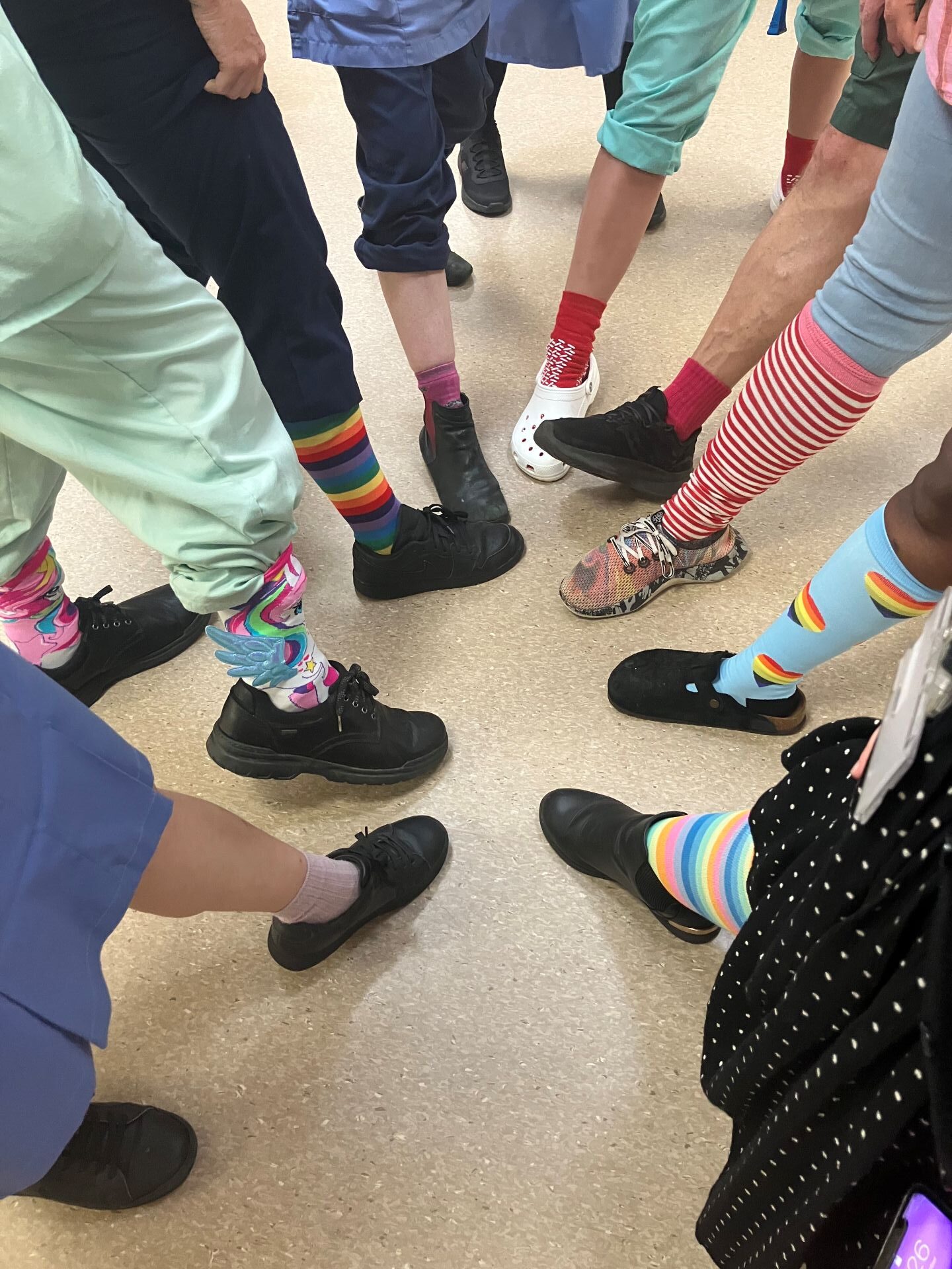 Colleagues marking Sepsis Awareness Day, wearing colourful socks.
